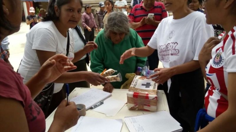 Una anciana ayuda a los maestros en uno de los puntos de donación. Foto: Facebook